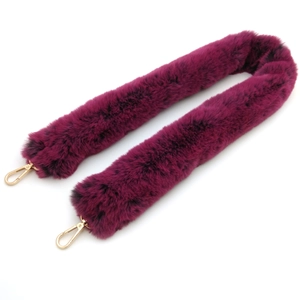 Close-up of deep magenta faux rabbit fur shoulder strap with gold metal lobster clasps