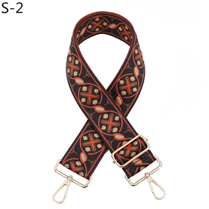 Close-up of ethnic geometric woven bag strap with navy, red patterns and gold hardware