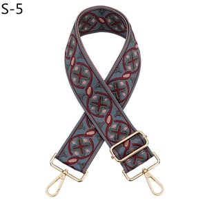 Detail of adjustable geometric jacquard canvas bag strap with gold metal hooks