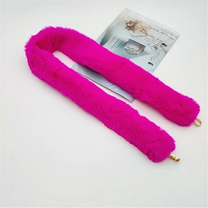 Close-up of fluffy fuchsia faux fur bag strap with shiny gold lobster clasps