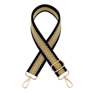 Close-up of woven geometric bag strap with gold metal buckle and lobster clasps