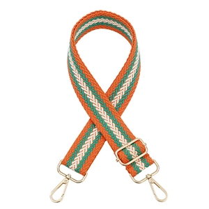 Detail of adjustable woven purse strap with orange wave pattern and gold metal hooks