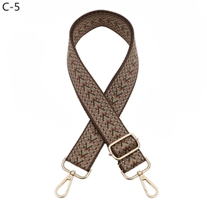 Détail d'une bandoulière tissée rétro réglable avec des fermoirs mousquetons dorés