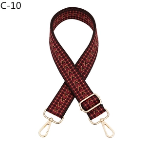 Détail de la bandoulière tissée rouge et noire réglable avec crochets métalliques dorés
