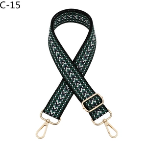 Détail d'une bandoulière tissée réglable aux motifs de vagues vert et noir avec boucles dorées