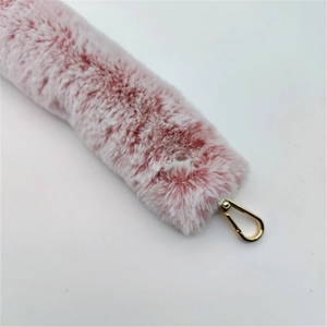 Detailed macro of soft pink plush strap with shiny gold metal lobster clasp fastener