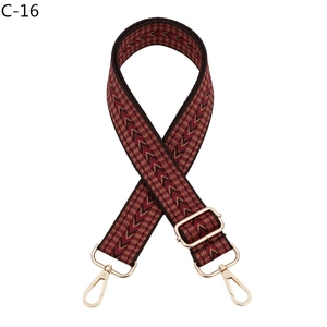 Detail of adjustable woven bag strap with retro geometric pattern and gold metal hooks