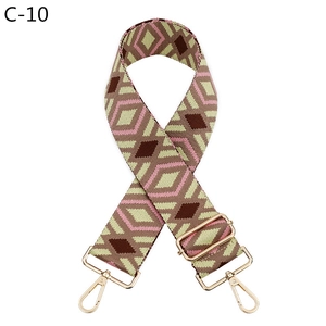 Detail of pink and brown geometric jacquard strap with gold metal hooks for crossbody bags