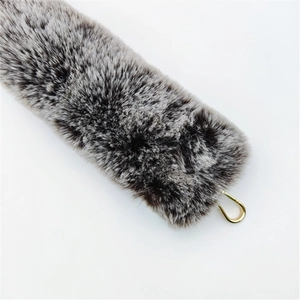 Detail of faux fur bag strap with black and white patterns and golden metal hook