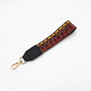 Close-up of ethnic woven wrist strap with geometric patterns and golden metal hook