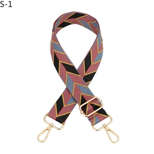 Detail of adjustable bag strap featuring red and black geometric V-pattern with gold hooks