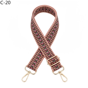 Detail of adjustable geometric patterned bag strap with durable golden metal lobster claws