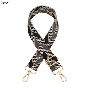 Detail of adjustable wide purse strap with golden buckles and chevron leaf pattern