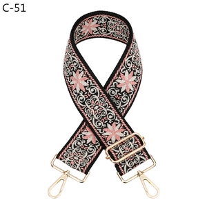Detail of bohemian floral embroidered bag strap with gold lobster clasps and canvas texture