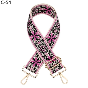 Detail of bohemian floral wide strap with pink and black patterns and gold metal hooks