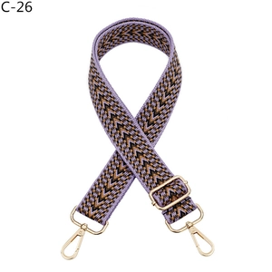 Detail view of purple chevron woven strap with adjustable gold buckle and snap hooks