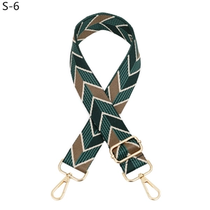 Detail of adjustable woven bag strap with green herringbone pattern and gold metal hardware