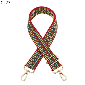 Close-up of ethnic V-pattern woven strap with golden metal lobster clasps and slider
