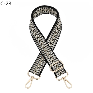 Close-up of adjustable woven shoulder strap with gold lobster clasps and herringbone pattern
