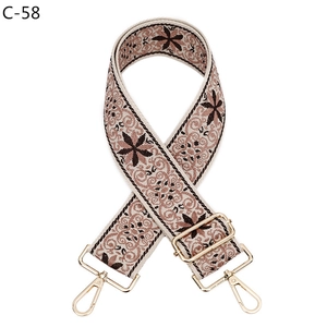 Detail of floral pattern jacquard woven strap with golden metal swivel hooks