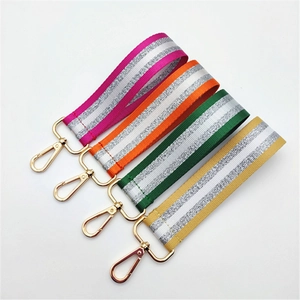 Four colorful glitter woven bag straps with gold lobster clasps in orange green and pink