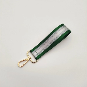 Detail of green and silver striped woven wrist strap with a gold metal lobster clasp