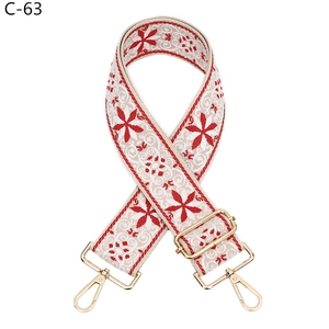 Detailed embroidery on wide adjustable handbag strap with golden metal lobster clasps
