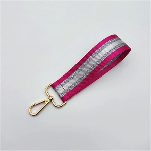 Close-up of rose red hand strap with silver glitter stripes and gold lobster clasp