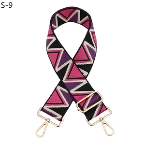 Detail of adjustable geometric strap with wave patterns and golden metal swivel hooks