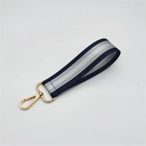 Detail of navy and silver striped woven wristlet strap with a gold lobster clasp