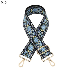 Close-up of bohemian embroidered strap with golden metal hooks and adjustable buckle