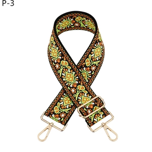 Close-up of ethnic dandelion embroidery and gold metal swivel hooks on bag strap