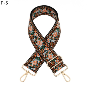 Close-up of bohemian dandelion patterned wide shoulder strap with gold metal hardware