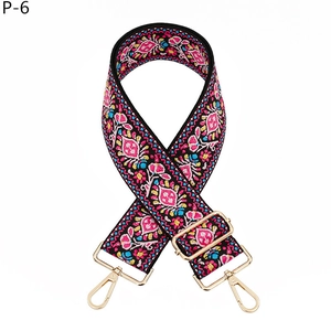 Detail of embroidered floral wide bag strap with golden metal lobster clasps and adjusters