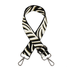 Adjustable black and white zebra pattern bag strap with gold threads and dark hardware