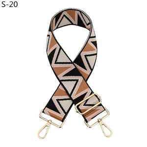 Detail of adjustable bag strap with black and brown geometric triangle pattern and gold hooks