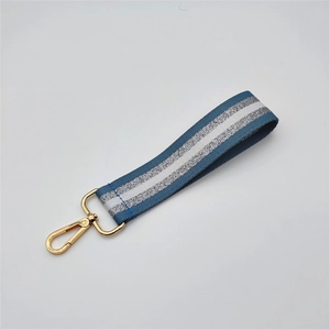 Close-up of blue and silver striped webbing hand strap with golden lobster clasp