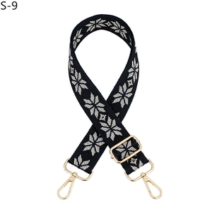 Detail of navy jacquard shoulder strap with white snowflake pattern and golden metal clips