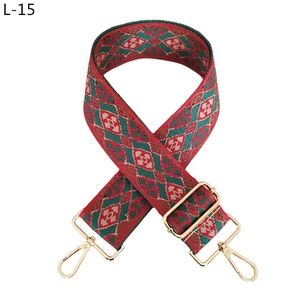 Detail of wide jacquard replacement strap with red geometric diamond pattern and gold hooks