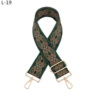 Close-up of woven fabric strap with green geometric pattern and gold metal buckles