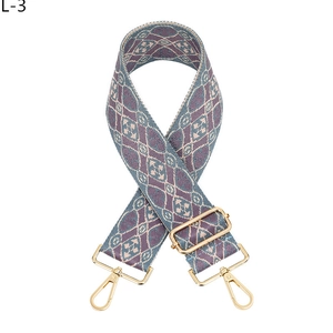 Makroansicht des blau-rosa Jacquard-Taschenriemens mit goldfarbenen Metallkarabinern