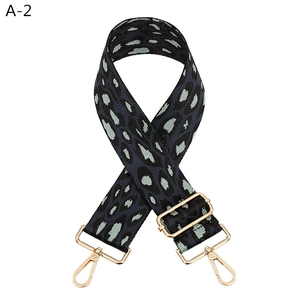 Close-up of leopard print bag strap in grey and mint green with golden metal hooks