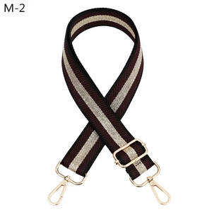 Detail of adjustable wine red and gold striped bag strap with gold metal swivel hooks
