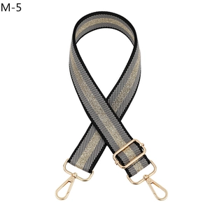 Detailed view of adjustable bag strap with black grey and gold metallic stripes