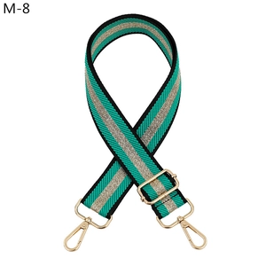 Close-up of green and black striped woven bag strap with golden metallic center line