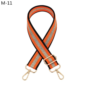 Detail of orange striped nylon bag strap with gold metal lobster clasps and buckles