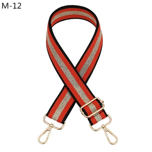 Macro detail of red, silver and black striped canvas replacement strap with gold hardware