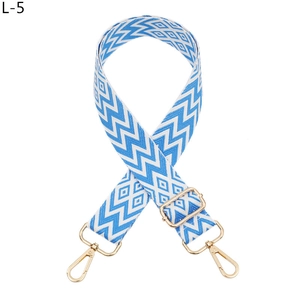 Detail of adjustable geometric blue and white woven bag strap with golden lobster clasp
