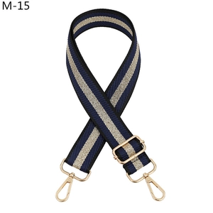 Macro detail of adjustable navy and gold striped woven bag strap with golden lobster claws