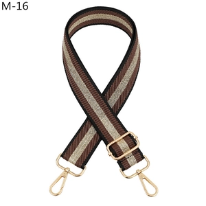 Detail of striped brown and gold nylon bag strap with polished metal lobster clasps